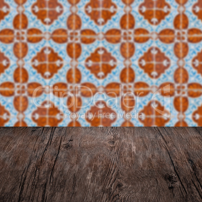 Wood table top and blur vintage ceramic tile pattern wall