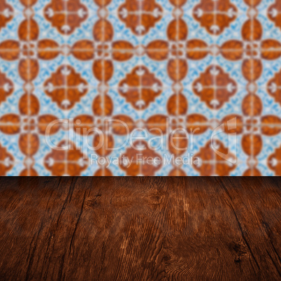 Wood table top and blur vintage ceramic tile pattern wall