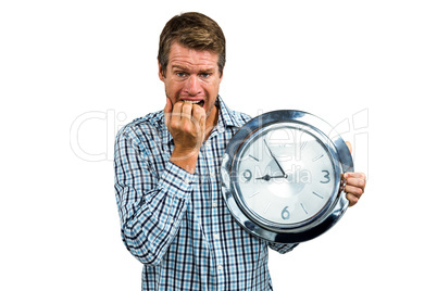 Anxious late man holding a clock