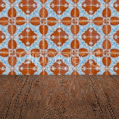 Wood table top and blur vintage ceramic tile pattern wall