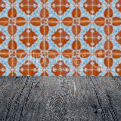 Wood table top and blur vintage ceramic tile pattern wall