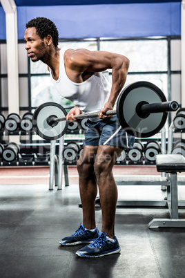 Muscular man exercising with barebell