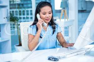 Smiling businesswoman using landline