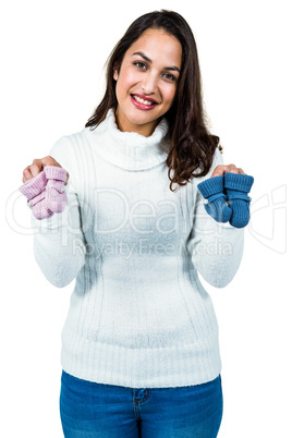 Portrait of happy young woman holding baby shoes
