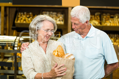 Senior couple holding bakery bag