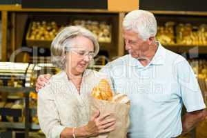 Senior couple holding bakery bag