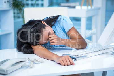 Tired businesswoman sleeping at her desk