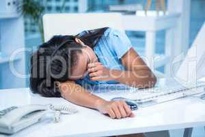 Tired businesswoman sleeping at her desk