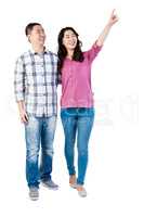 Happy couple pointing upwards