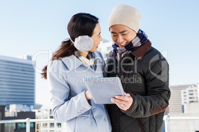 Smiling couple holding tablet computer