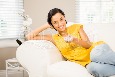 Smiling brunette using remote