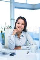 Smiling businesswoman with chin on fist