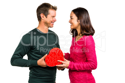 Happy young couple holding heart shaped gift