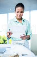 Smiling businesswoman sitting on her desk