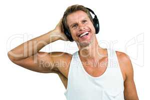 Smiling man hearing music from headphones