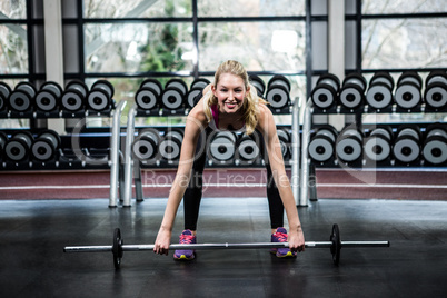 Smiling fit woman lifting barebell
