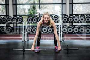 Smiling fit woman lifting barebell