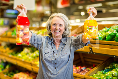 Senior happy woman holding bag of fruits
