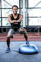 Fit man doing exercise with bosu ball