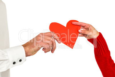 Couple hands holding heart shaped paper