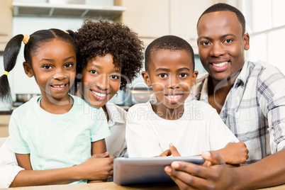 Happy family using tablet in kitchen