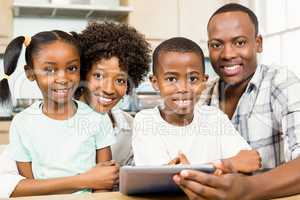 Happy family using tablet in kitchen