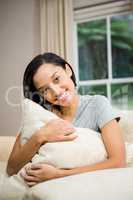 Smiling brunette holding pillow