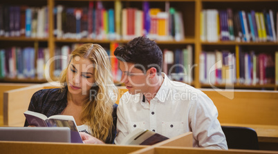 Smiling students working together while sitting at table