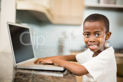 Smiling boy using laptop