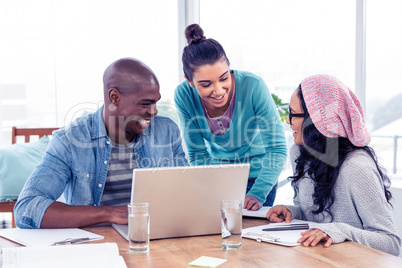 Young business people discussing over laptop in office