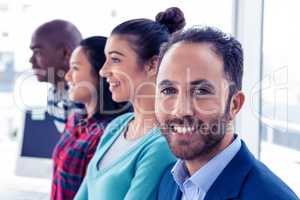 Portrait of young businessman with colleagues