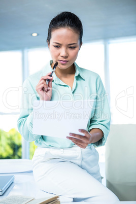 Smiling businesswoman sitting on her desk Smiling businesswoman sitting on her desk