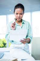 Smiling businesswoman sitting on her desk