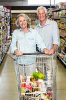 Smiling senior couple with cart