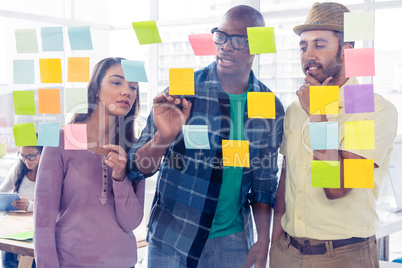 Creative business people discussing over adhesive notes