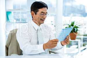 Smiling asian businessman using tablet