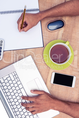 Overhead view of businessman working on laptop