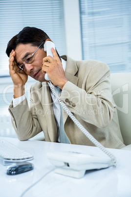 Troubled asian businessman on the phone