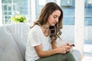 Woman texting on sofa