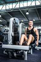 Muscular man using exercise machine for legs