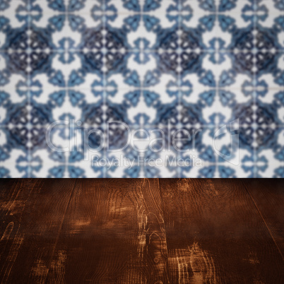 Wood table top and blur vintage ceramic tile pattern wall