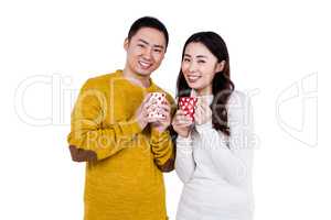 Portrait of happy young couple holding cups