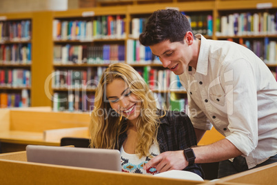 Smiling students working together while sitting at table