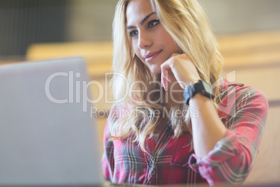 Smiling female student using laptop