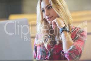 Smiling female student using laptop