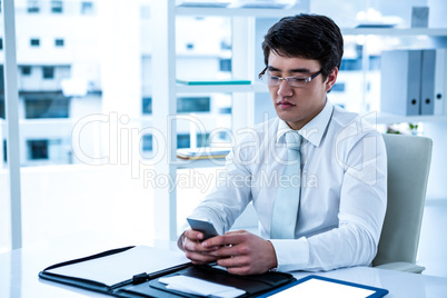 Focused asian businessman using his phone