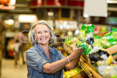 Senior happy woman holding bag of salad