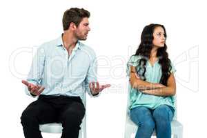 Couple sitting on chairs having argument