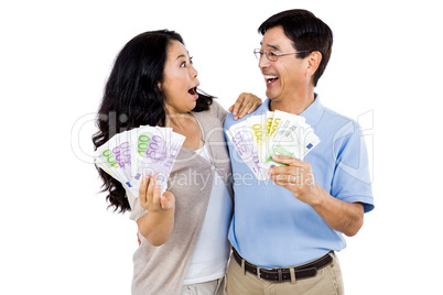 Smiling couple with two fans of cash