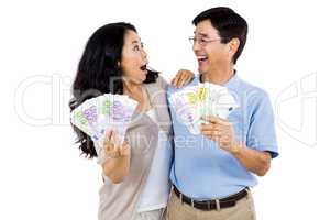 Smiling couple with two fans of cash